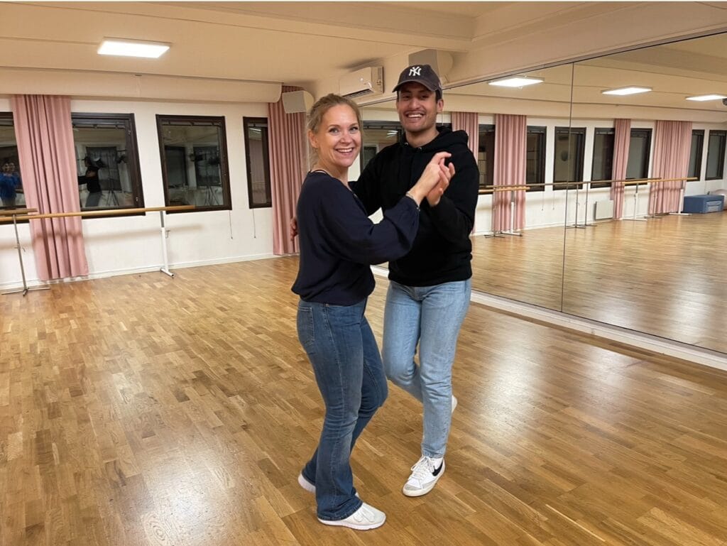 Erik Diaz och Marlena Larsson dansar salsa i en dansstudio.