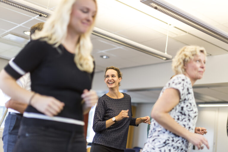 Glada medarbetare deltar i en företagshälsovårdsaktivitet för teambuilding.
